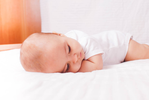 Baby lying on the bed and falling asleep - Φωτογραφία, εικόνα