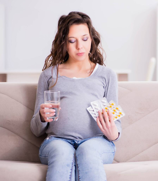 Pregnant woman sitting on sofa - Foto, Imagem