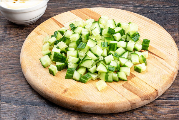 Sliced fresh cucumber on a wooden cutting board. Salad ingredients. - Zdjęcie, obraz