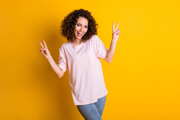 Photo portrait of girl showing two v-signs isolated on vivid yellow colored background - Φωτογραφία, εικόνα