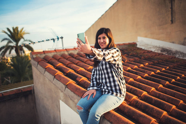 Kreativní dívka pracuje ze střechy svého domu - Fotografie, Obrázek