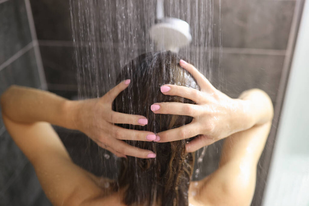 Femme prend une douche dans la salle de bain gros plan - Photo, image