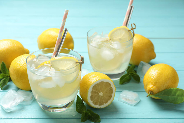 Natural lemonade and fresh fruits on light blue wooden table. Summer refreshing drink - Foto, Bild