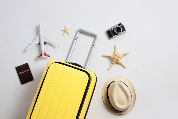 Flat lay composition with suitcase and travel accessories on grey background. Summer vacation - Фото, изображение