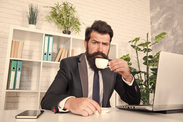 Comfy workspace. Bearded hipster formal suit relaxing with coffee. Office life is unthinkable without good coffee. Reception room. Respectable ceo. Man handsome boss sit in office drinking coffee - 写真・画像