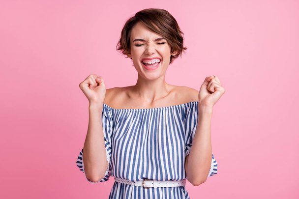 Photo portrait of happy woman celebrating with fists up isolated on pastel pink colored background - Zdjęcie, obraz