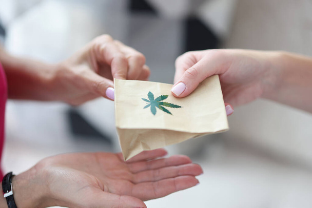 Handing over paper bag with marijuana sign. - Photo, Image