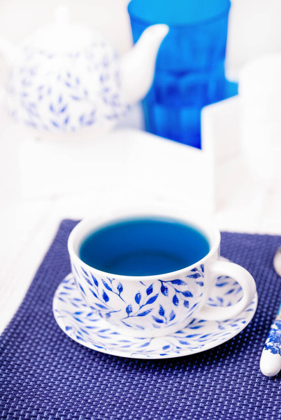Kubek porcelany organiczny niebieski motyl groch herbata kwiat, białe tło - Zdjęcie, obraz