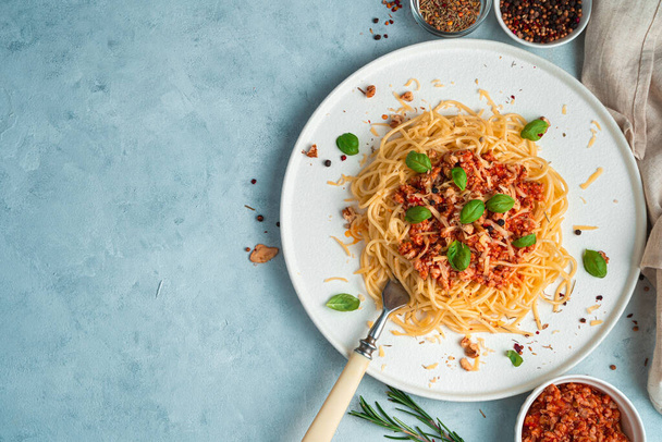 Kulinářské pozadí se špagetami a boloňskou omáčkou na modrošedém pozadí. - Fotografie, Obrázek