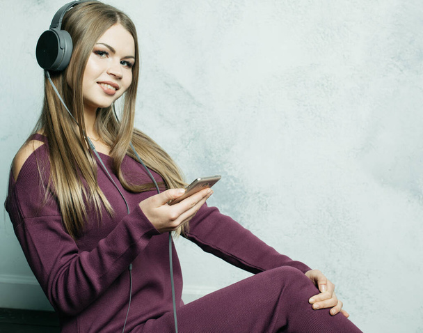 people and technology concept - happy young woman in headphones listening to music from smartphone - Foto, immagini