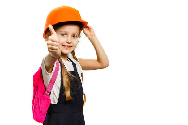 Cute little girl is isolated on white background. Girl looking at camera, wearing yellow helmet - Foto, Imagem