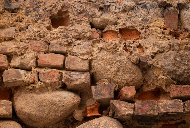 Oude oude roodoranje bruine baksteen en stenen muur met oud metselwerk in oud gebouw - Foto, afbeelding