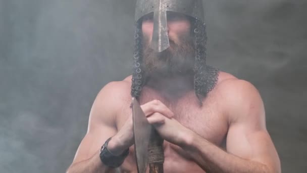 Nord wojownik trzyma topór z rękami w tle dymu - Materiał filmowy, wideo