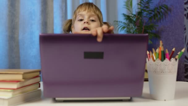 kleuterschoolmeisje afstand online onderwijs thuis, leerling studeren met leraar met behulp van laptop - Video