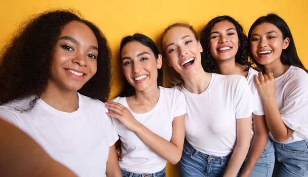 Grupa pięciu kobiet robi selfie stojąc nad żółtym tle - Zdjęcie, obraz