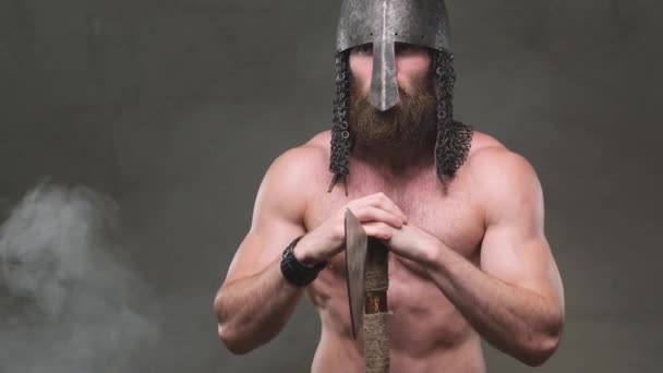 Nord πολεμιστής ποζάρουν με τσεκούρι και κράνος σε φόντο smokey - Πλάνα, βίντεο