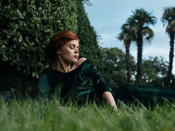 Elegant woman lies on the grass outdoors nature luxury decoration - Фото, изображение