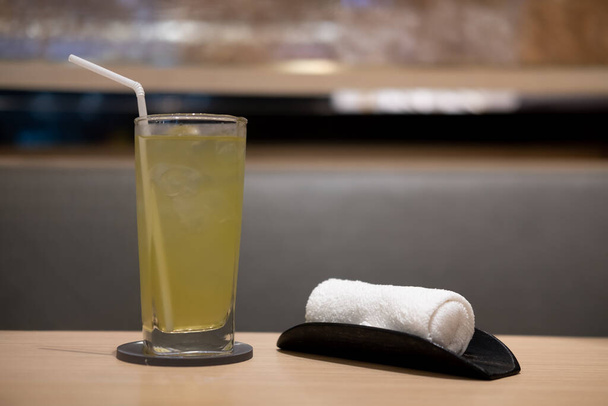 Ледяной зеленый чай и полотенце для рук в японском ресторане для очистки руки перед едой - Фото, изображение