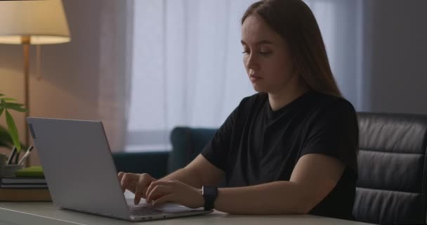 väsynyt nainen sulkee kannen kannettavan tietokoneen ja koskettaa päätään, tunne kipua ja väsymystä pitkän tietokoneen kanssa työskentelyn jälkeen - Materiaali, video