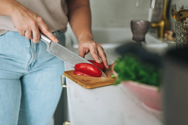 Гарна брюнетка молода жінка плюс розмір тіла позитивний салат для приготування їжі на кухні вдома
 - Фото, зображення