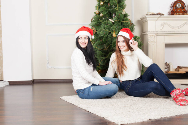 Happy two girlfriends near christmas tree - Zdjęcie, obraz