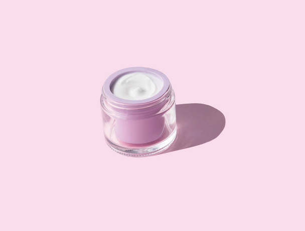 Λευκή κρέμα προσώπου σε ροζ βάζο. Φροντίδα δέρματος ομορφιάς - Φωτογραφία, εικόνα