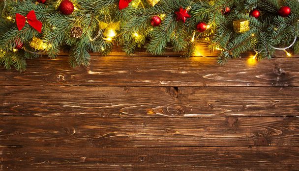 Christmas decoration and christmas lights frame on wooden background. - Фото, изображение
