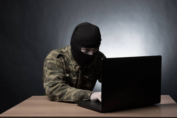 Masked cyber terrorist in military uniform hacking army intelligence - Zdjęcie, obraz