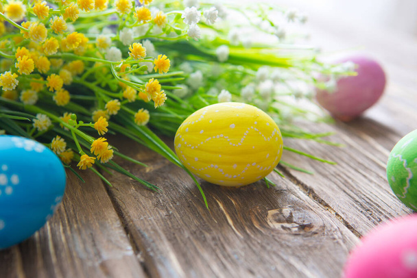Easter eggs and spring flowers on an old wooden background. - Foto, Imagem