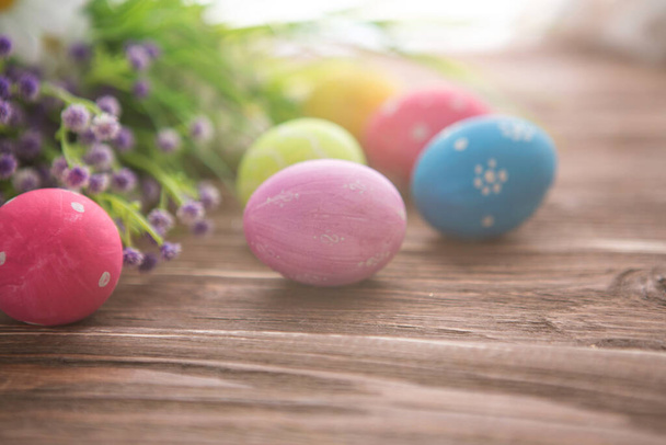 Colorful pastel easter eggs with flowers on a wooden board background - Foto, Imagem