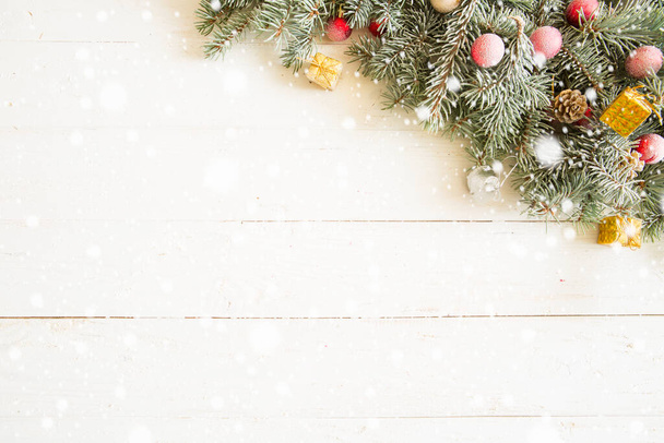 Fir branch with Christmas decorations on the white wooden table or plank background. - Photo, image