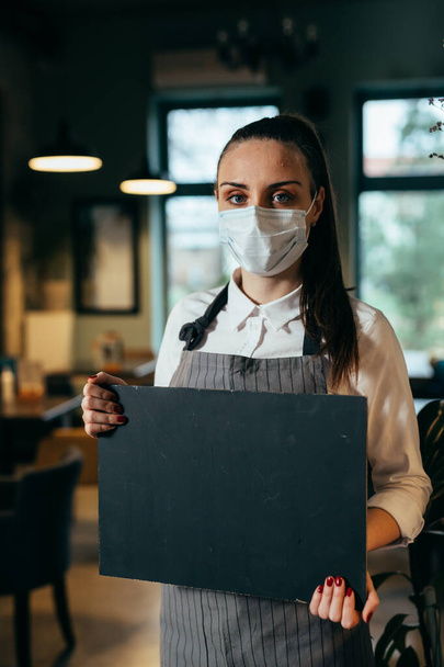 camarera sosteniendo letrero en blanco en restaurante - Foto, imagen