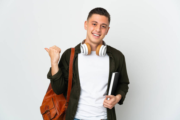Jeune étudiant caucasien homme isolé sur fond blanc pointant vers le côté pour présenter un produit - Photo, image