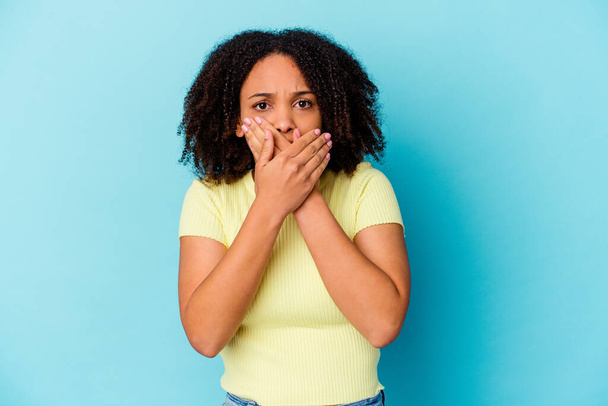 Young african american mixed race woman isolated covering mouth with hands looking worried. - Foto, Imagen