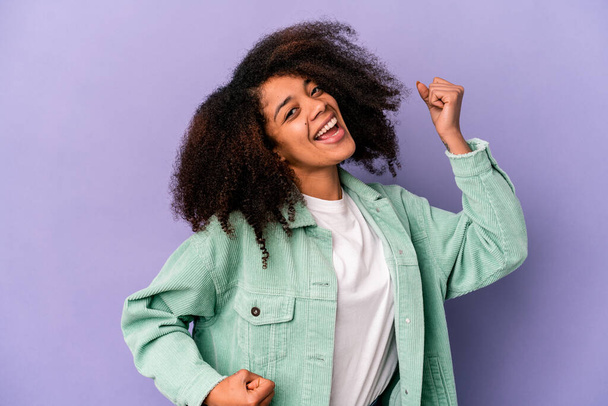 Young african american curly woman isolated on purple background cheering carefree and excited. Victory concept. - Fotografie, Obrázek