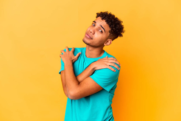 Jeune homme frisé afro-américain isolé sur des câlins violets, souriant insouciant et heureux. - Photo, image