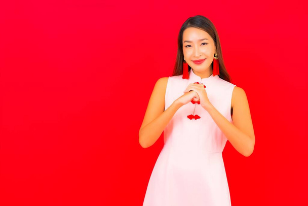 Ritratto bella giovane donna asiatica indossare cinese nuovo anno abbigliamento su sfondo rosso - Foto, immagini