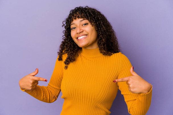 Молодая африканская американка афро-женщина изолирована указывает пальцами вниз, позитивное чувство. - Фото, изображение