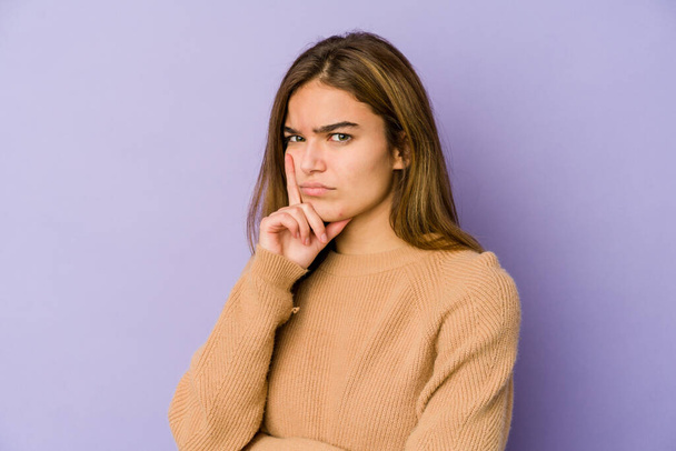 Young skinny caucasian girl teenager on purple background contemplating, planning a strategy, thinking about the way of a business. - Photo, image