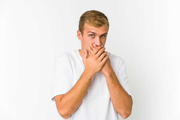 Junge kaukasische gutaussehende Mann bedeckt Mund mit Händen suchen besorgt. - Foto, Bild