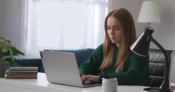 femme concentrée travaille à la maison, dactylographier du texte sur le clavier de l'ordinateur portable, travail à distance pour les jeunes femmes en congé de maternité - Séquence, vidéo