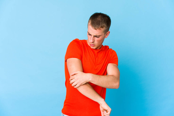 Young caucasian handsome man massaging elbow, suffering after a bad movement. - Photo, Image