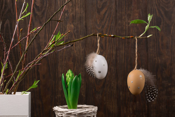 Spring Easter holiday greeting card background. Easter Decoration with tree branches, eggs, quail feathers, hyacinth flower on dark wooden background. Happy Easter card concept.  - Foto, immagini
