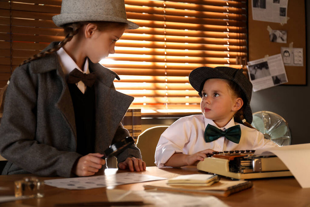 Cute little detectives at table in office - Photo, Image