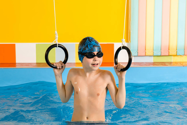 Criança em piscina excersizing com anéis desportivos - Foto, Imagem