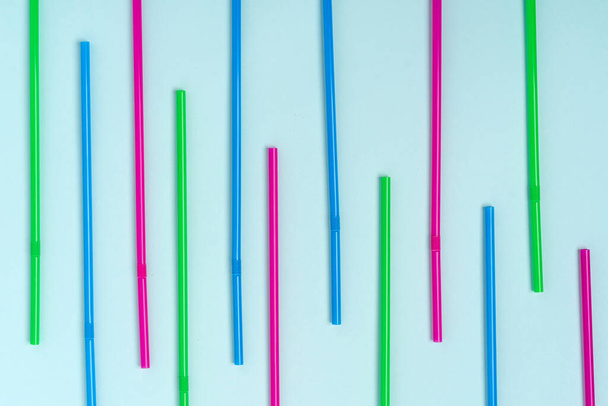 A pattern of colored beverage tubes laid out on a blue background - Fotó, kép