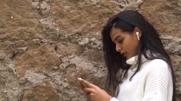 Perdere tempo online. Giovane ragazza adolescente guardando verso il basso il suo smartphone. Focus selettivo - Filmati, video