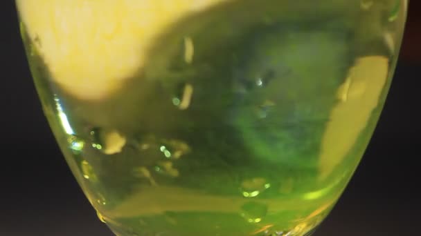 Γυάλινη σαμπάνια με νερό και υγρό χρώμα ρέει  - Πλάνα, βίντεο