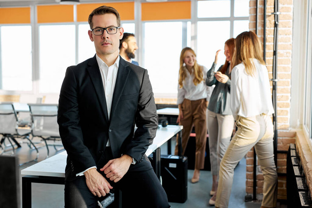 portrait of successful caucasian businessman in suit posing at camera in office - Photo, image