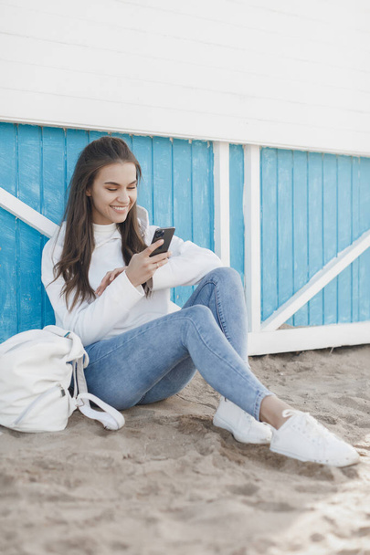 Young happy smiling casual woman with phone - Фото, изображение